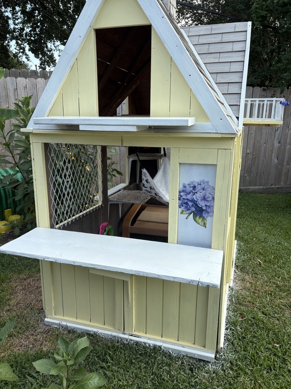 Side view of the cat cottage showing the serving-counter shelf and interior perches